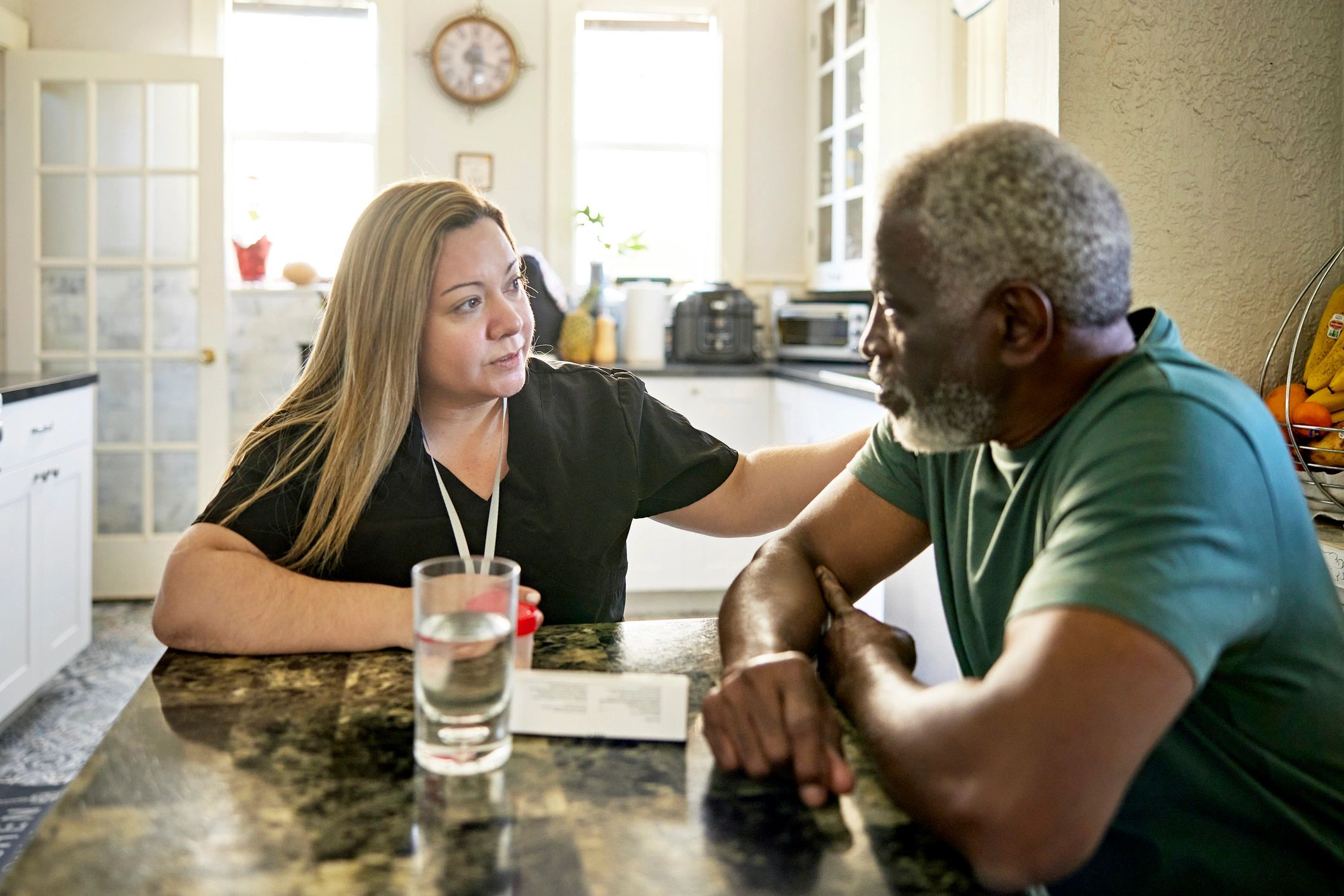 Care professional speaking with a client at home